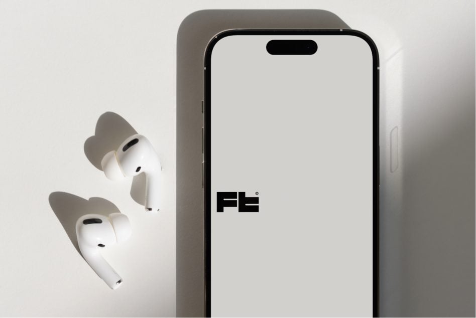 Modern smartphone with white earbuds on minimal gray studio background